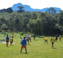 Moradores jogando futebol no gramado comunitário, com borda decorativa